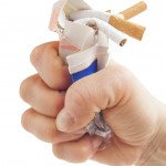 Human fist breaking pack of cigarettes Anti smoking concept