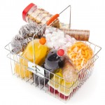 Shopping basket with assortment of unhealthy food on white background